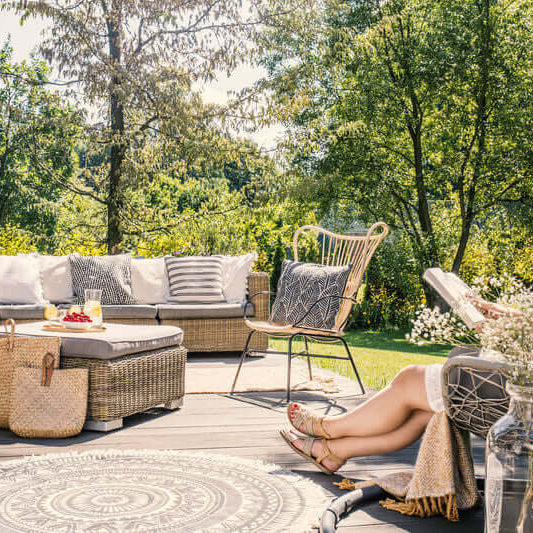 WADE BUILDING SUPPLIES | CREATE OUTDOOR SPACE FOR RELAXATION LADY ON DECKING WITH FURNITURE READING