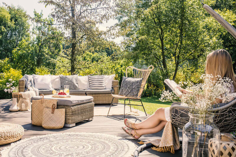 WADE BUILDING SUPPLIES | CREATE OUTDOOR SPACE FOR RELAXATION LADY ON DECKING WITH FURNITURE READING