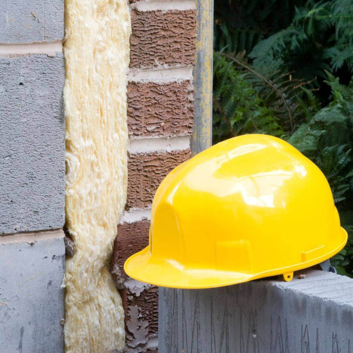 WADE BUILDING SUPPLIES | BUILDERS HAT SAT ON CAVITY WALL SHOWING WHERE INSULATION HAS BEEN FITTED